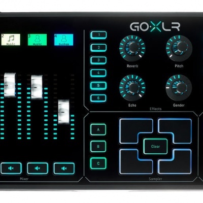 Dispositivo GOXLR preto com botões iluminados e faders em fundo branco