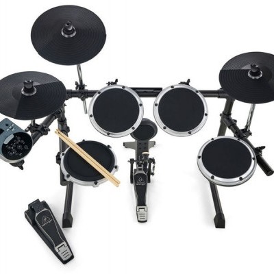 Bateria eletrónica com pads pretos e aro prata, baquetas e pedal