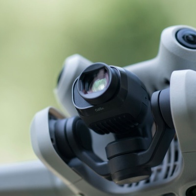 Drone com câmara preta em estrutura giratória com fundo verde desfocado