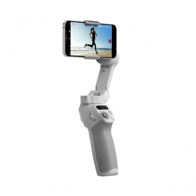 Gimbal estabilizador de smartphone cinza claro com telemóvel preto a mostrar mulher a correr na praia