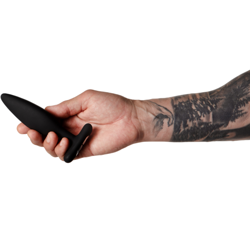 JE JOUE EGON – Vibrador Anal Premium com Design Escultural Braço tatuado segurando plugue anal preto de silicone.