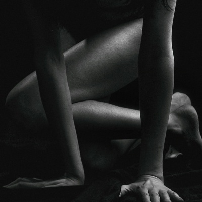 Imagem a preto e branco de modelo em pose de quatro apoios, com pele visível em destaque