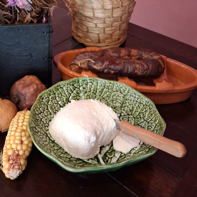 Queijo fresco branco em travessa verde em forma de folha com faca de cabo de madeira