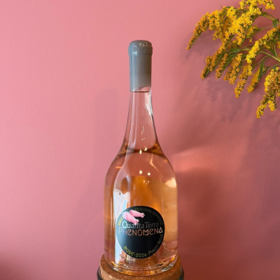 Garrafa de vinho rosé com etiqueta preta na base cortiça com flores amarelas ao lado