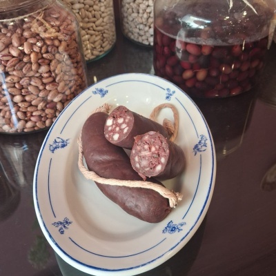 Chouriço de sangue e frascos com feijão em mesa