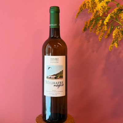 Garrafa de vinho branco Milhafre Negro com rótulo em fundo rosa e flores amarelas