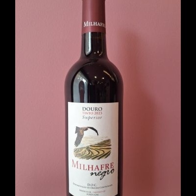 Garrafa de vinho tinto Milhafre negro com rótulo branco e desenho de ave