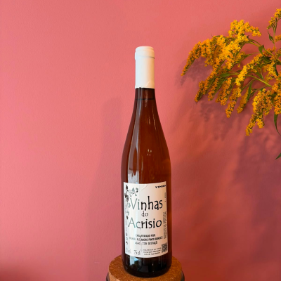 Garrafa de vinho com rótulo branco e flores amarelas ao lado