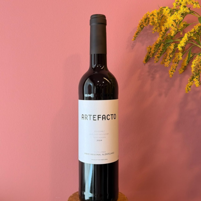 Garrafa de vinho tinto Artefacto com rótulo branco e flores amarelas ao fundo