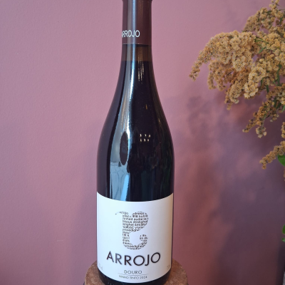 Garrafa de vinho tinto ARROJO com rótulo branco e fundo rosa