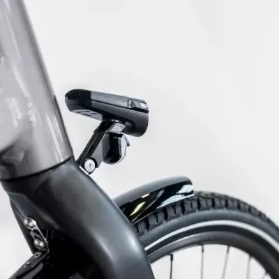 Parte traseira de uma bicicleta com quadro cinzento, suporte de luz, guarda-lamas e pneu