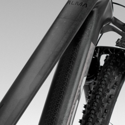 Quadro preto fosco de bicicleta de montanha com pneus de cravos largos e texto ALMA