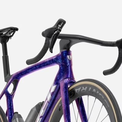 Bicicleta de estrada azul metálico e roxo com componentes pretos e pneus VITTORIA