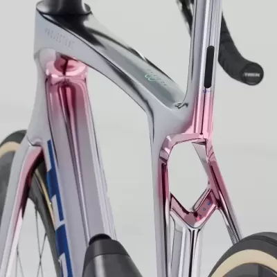 Quadro e garfo de bicicleta em carbono com acabamento cromado rosa e prata, pneus pretos com bordas bege