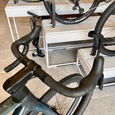 Bicicleta de estrada verde escuro com guiador em curva e pneus pretos em exposição interior