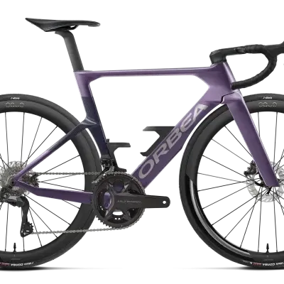 Bicicleta de estrada de carbono roxo escuro com rodas altas e pneus Vittoria.