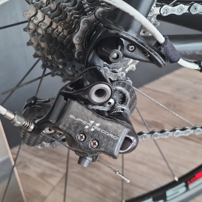 Desviador traseiro de bicicleta preto em carbono com texto SUPER RECORD e corrente metálica