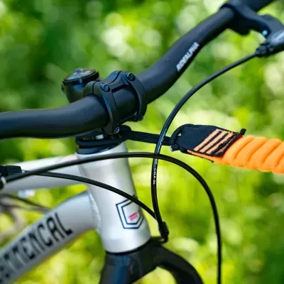 Close-up de guiador e quadro de bicicleta com bracelete preta e laranja