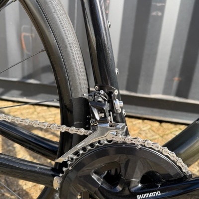 Pedalier e desviador dianteiro Shimano 105 em bicicleta preta com corrente metálica