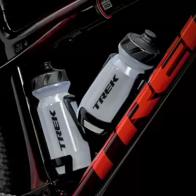 Duas garrafas de água TREK em suporte numa bicicleta preta e vermelha