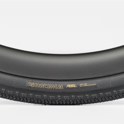 Pneu preto para bicicleta com inscrições douradas e padrão texturizado