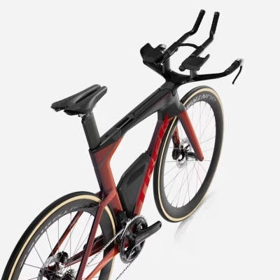 Bicicleta de estrada preta e vermelha com pneus bege e guiador aerodinâmico