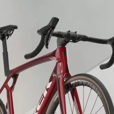 Bicicleta de estrada vermelha e preta com quadro aerodinâmico e guiador curvo