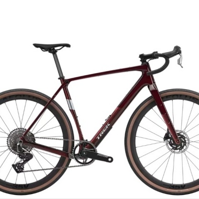 Bicicleta de estrada bordô com pneus castanhos e pretos em fundo branco