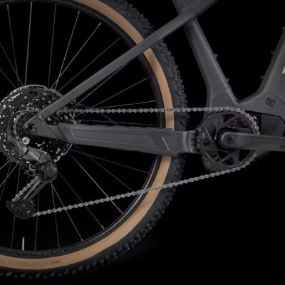 Parte traseira de bicicleta preta com pneu bege e a palavra TREK na estrutura