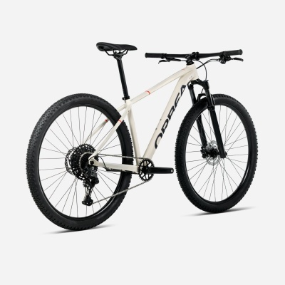 Bicicleta de montanha bege com pneus pretos largos e texto NORCO no quadro