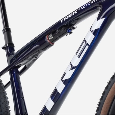 Quadro de bicicleta azul escura com texto branco e amortecedor traseiro