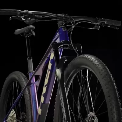 Bicicleta de montanha roxa e azul com pneus grossos e guiador preto