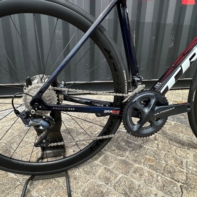 Bicicleta de estrada com quadro carbono preto e vermelho e componentes Shimano.