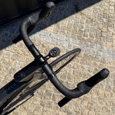 Guiador preto de bicicleta de estrada com fita antiderrapante e pavimento em calçada