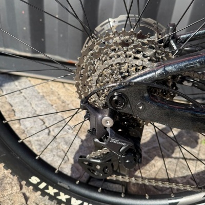 Roda traseira de bicicleta com componentes metálicos e pneu Maxxis preto