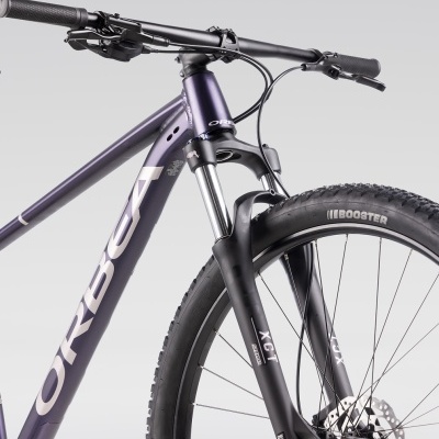 Bicicleta de montanha Orbea roxa com suspensão e pneus Boosters pretos