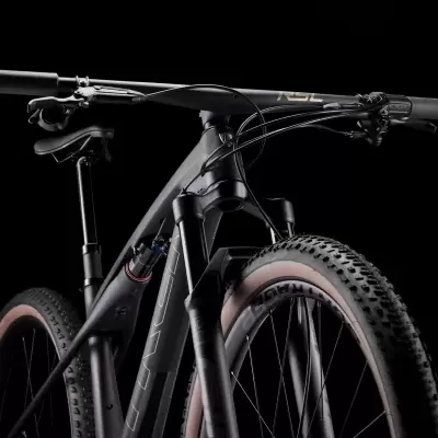 Bicicleta de montanha preta com suspensão dianteira e pneus grossos