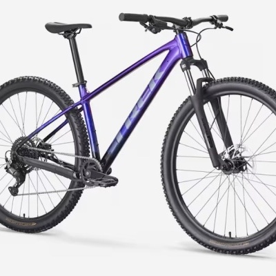 Bicicleta de montanha TREK roxo e preto com pneus largos e suspensão dianteira