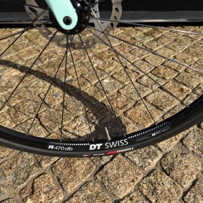 Roda de bicicleta preto com aro DT Swiss e pavimento de pedras