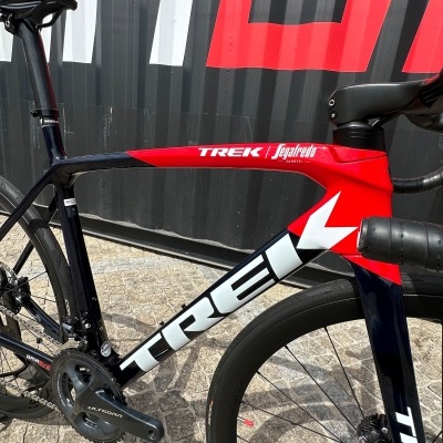 Bicicleta de estrada Trek carbono preta, branca e vermelha com componentes Shimano