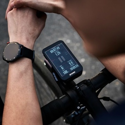 Computador de bicicleta digital montado em guiador preto com mão usando relógio preto