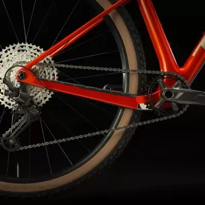 Detalhe da roda traseira e sistema de transmissão de bicicleta laranja