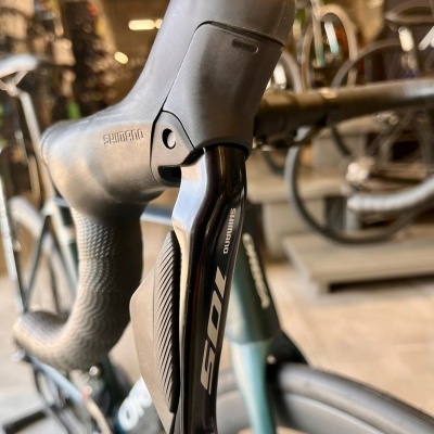 Punho de mudança de velocidades Shimano 105 preto montado num guiador de bicicleta