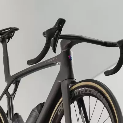 Bicicleta de estrada preta com guiador drop e pneus com inscrição