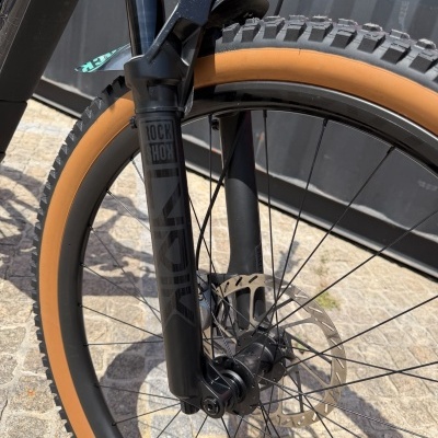 Roda de bicicleta com pneu castanho e garfo RockShox