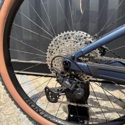 Roda traseira de bicicleta com pneu castanho e sistema de mudanças Shimano XT