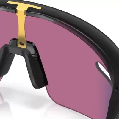 Óculos desportivos com armação preta, ponteiro dourado e lentes cor-de-rosa