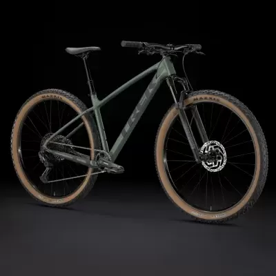 Bicicleta de montanha verde-acinzentada com pneus castanho claro em fundo preto