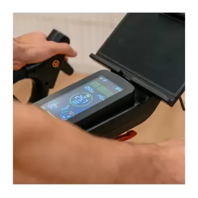 Painel digital colorido de bicicleta estática com dados visíveis e mãos segurando guidão