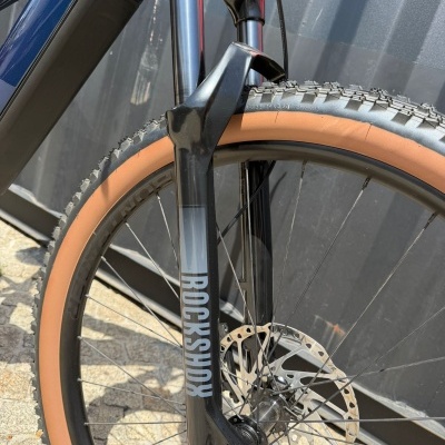 Roda dianteira de bicicleta com suspensão Rockshox e pneu castanho